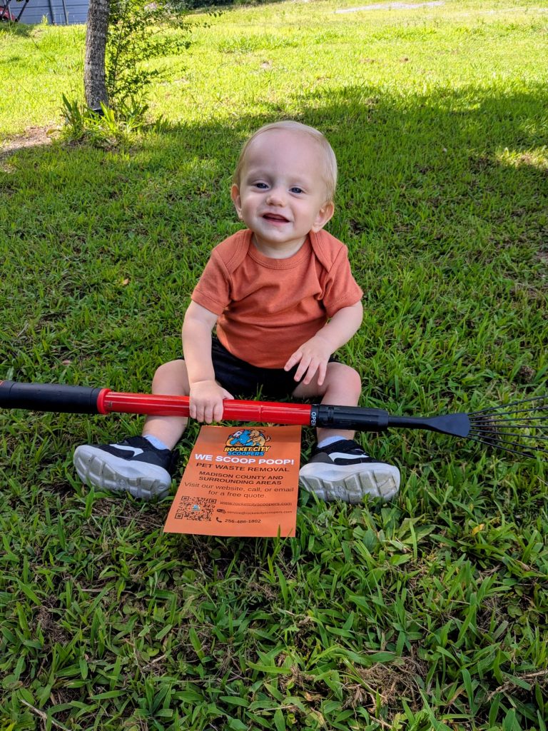 A young Rocket City Scoopers family member in a green yard